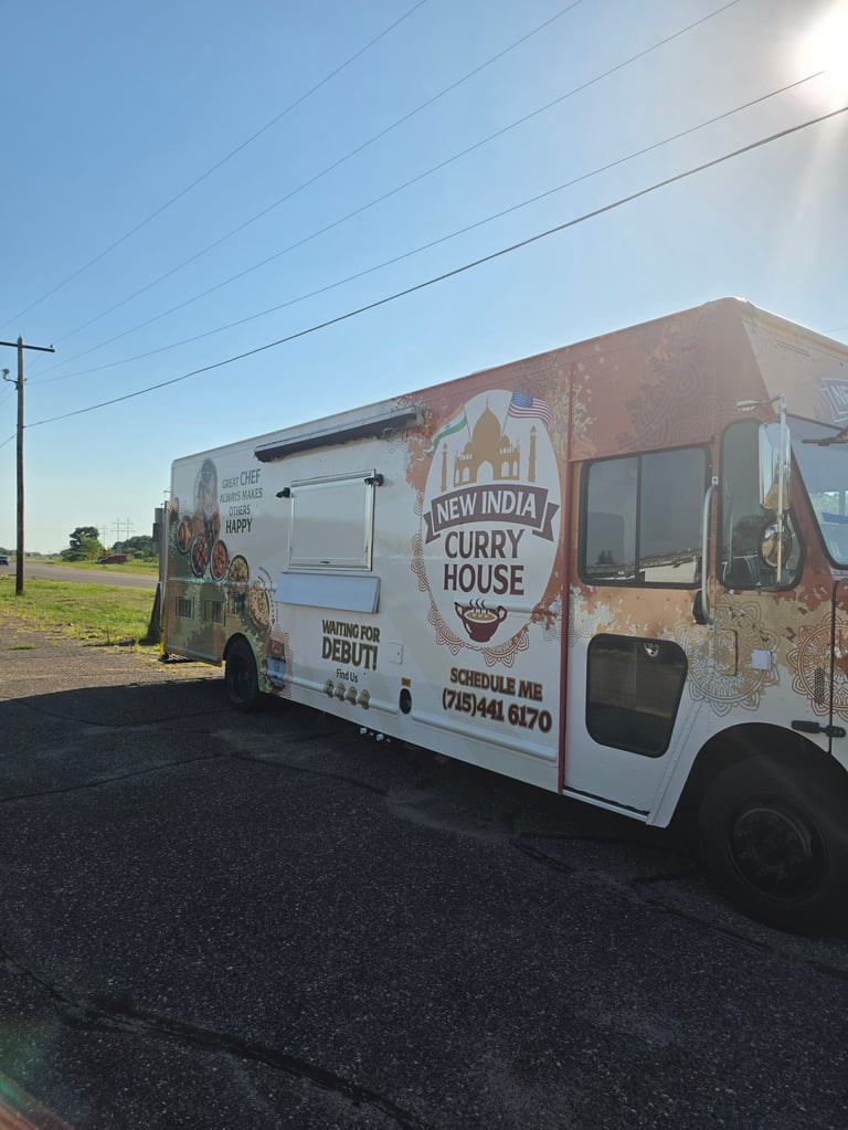 New India Curry House food truck parked on rural roadside with clear blue sky and power lines visible